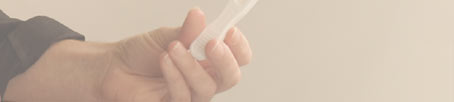Left hand of a woman hoding a home pregnancy test.